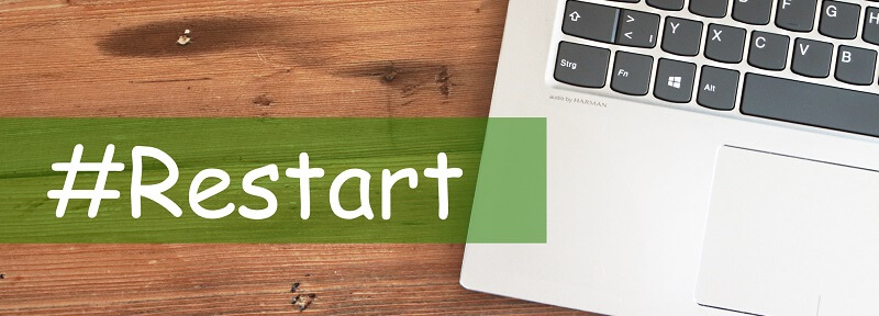 Ein Laptop auf dem Tisch mit dem Hashtag "Restart"